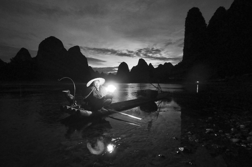 A picture of a cormorant fishermen with gas lamp on the li river