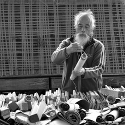A Chinese man unwinding a scroll at the flea market